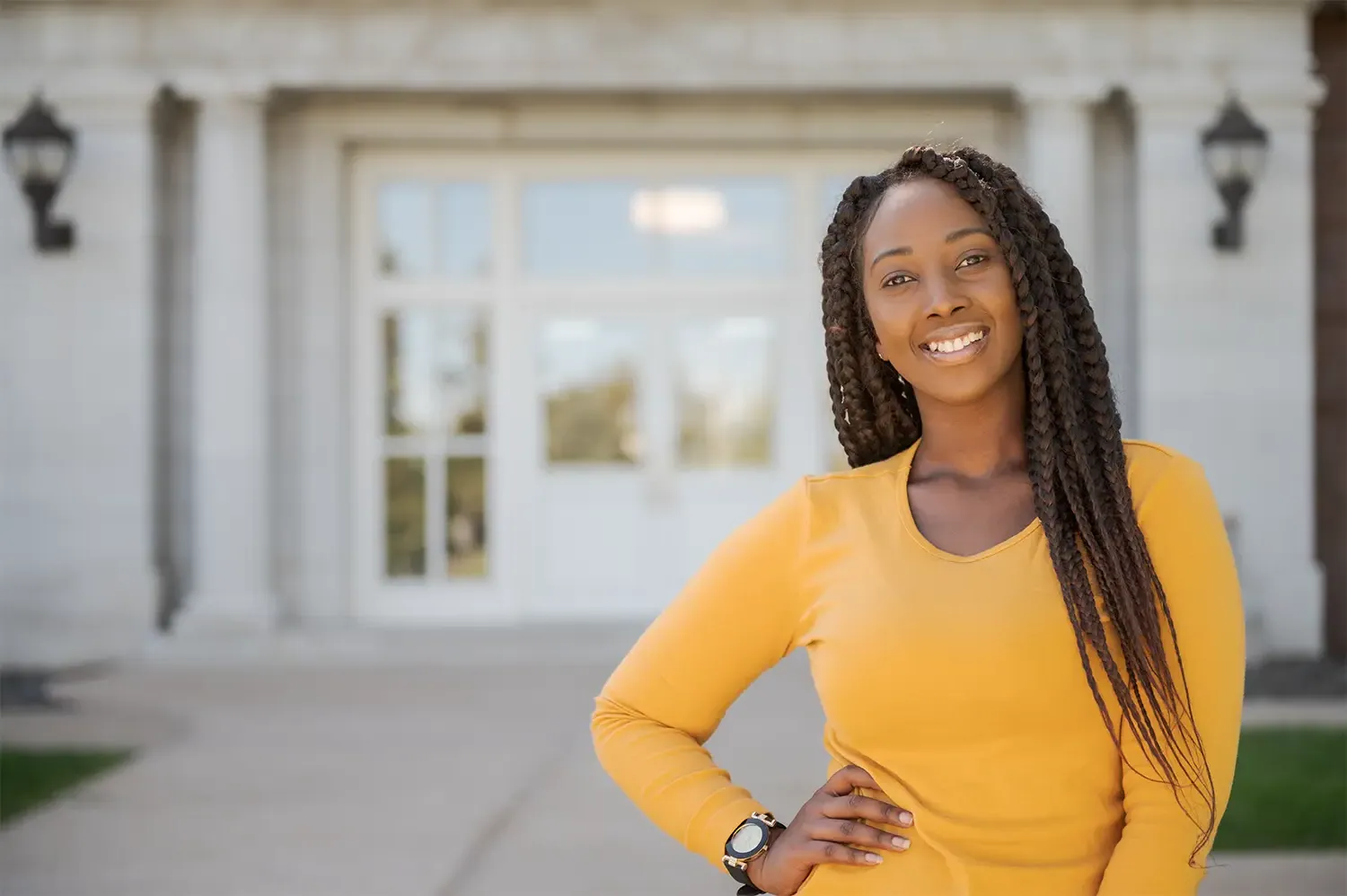 A student smiles in front of Old Admin